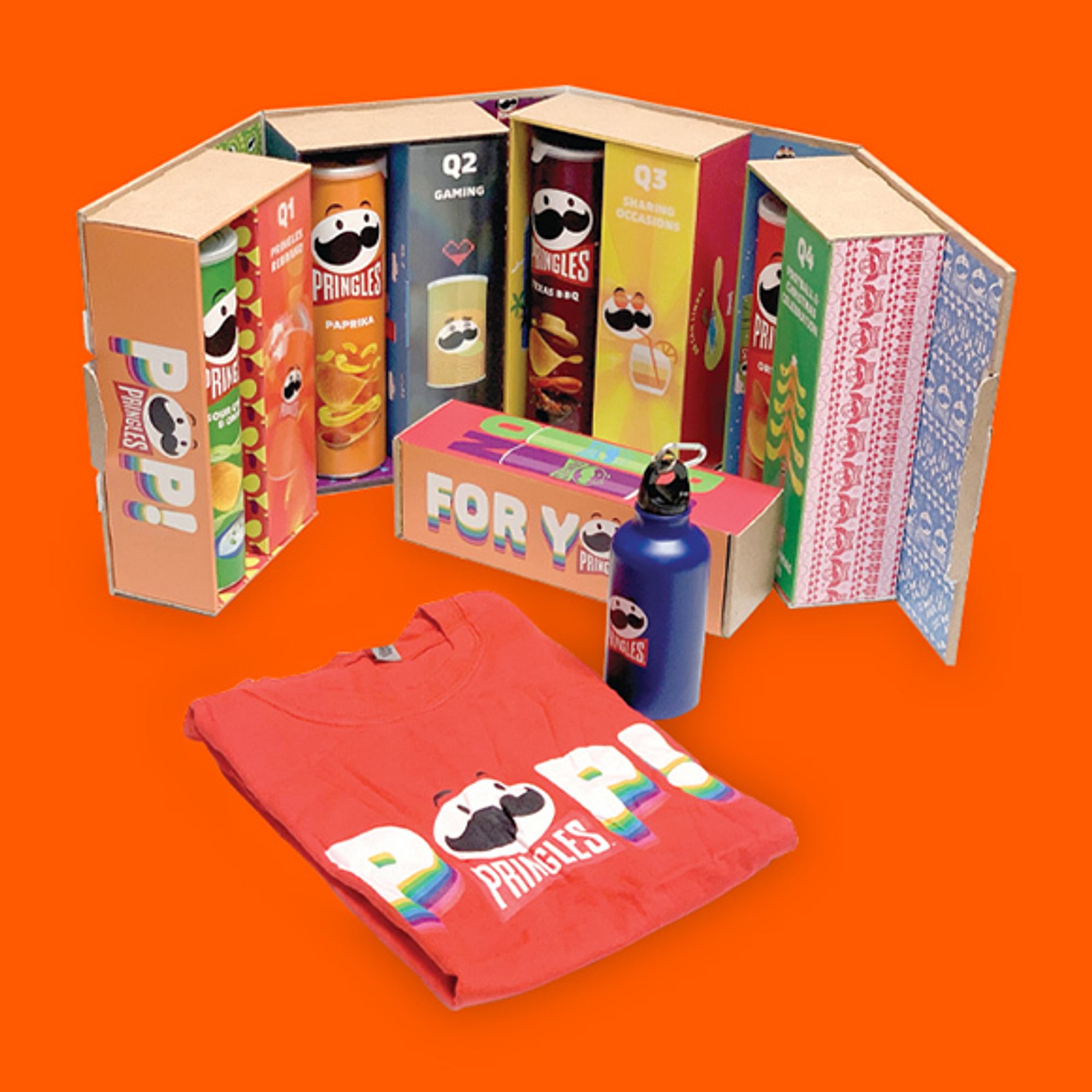 A fold-out buyers box filled with tubes of Pringles, a branded t-shirt and branded water bottle