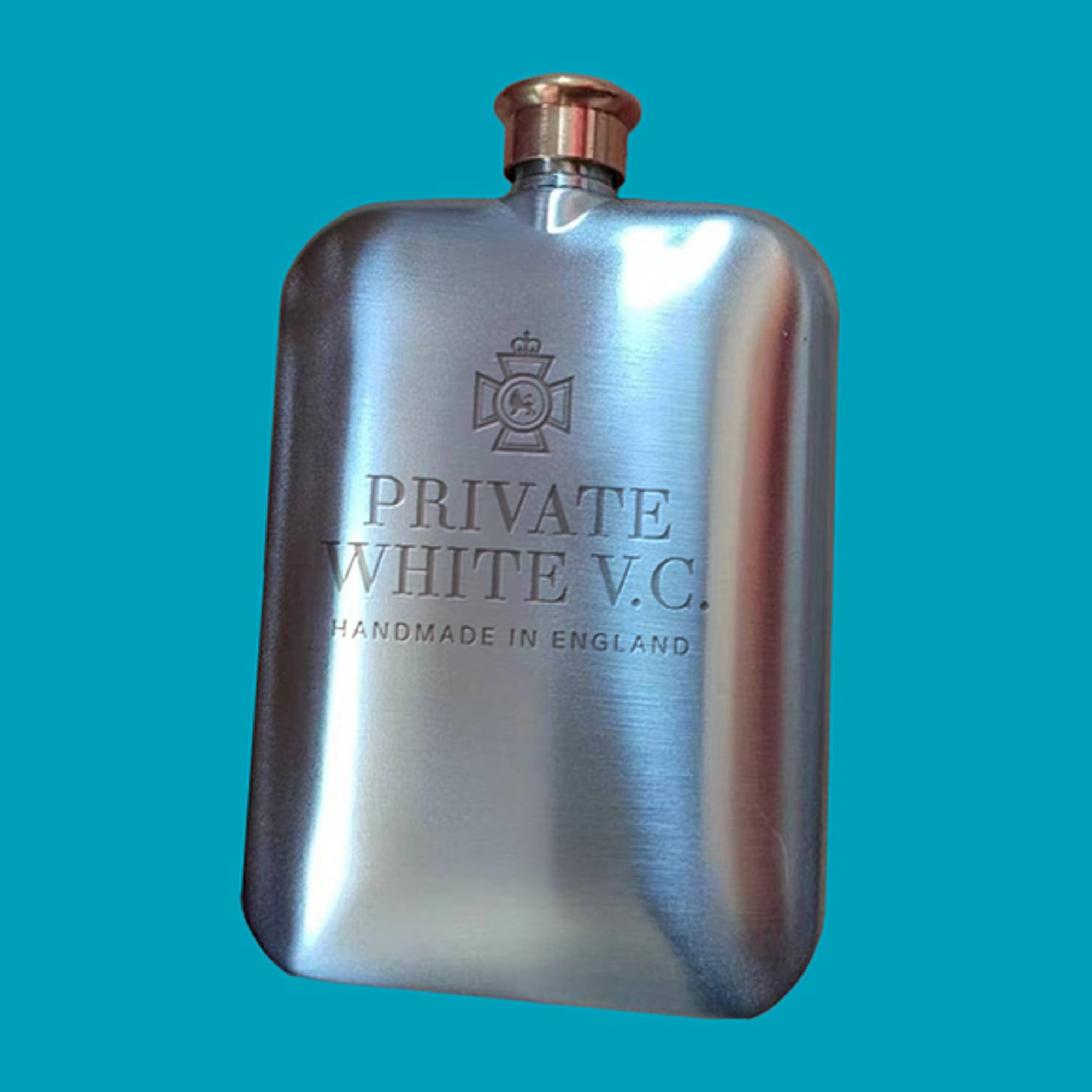 A branded silver hip flask with a copper screw cap and Private White V.C. branding